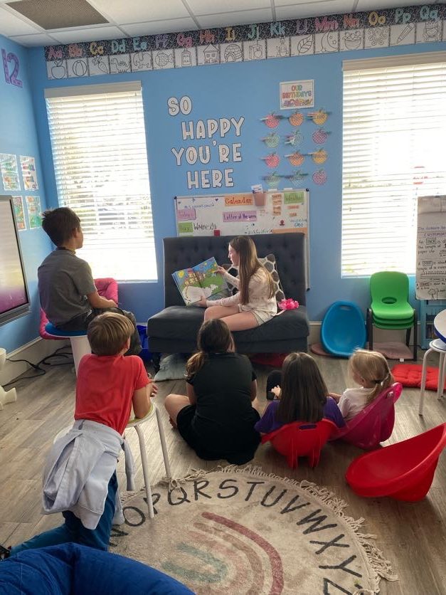 A teacher reading aloud on the rug