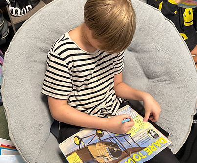 Student reading independently in a comfortable pillow chair, demonstrating individualized learning at 3 Oaks Academy